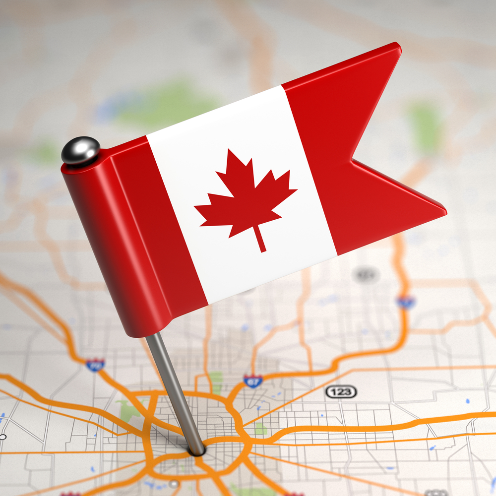 Small-Flag-of-Canada-on-a-Map-Background-with-Selective-Focus.